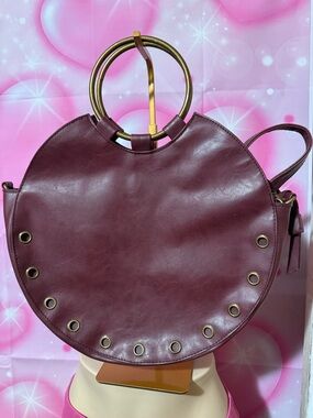 Round Burgundy Shoulder Bag with Gold Ring Handles and Grommet Detail